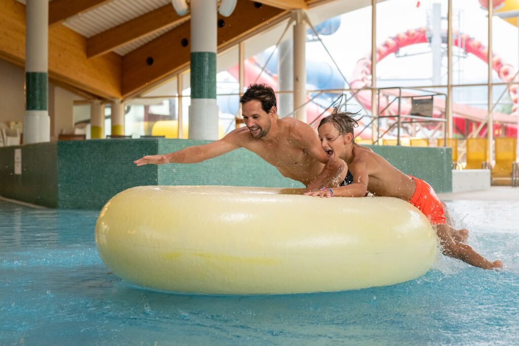 Vater und Sohn haben Spaß in der Erlebnis-Therme Amadé während ihres Sommerurlaub Altenmarkt Zauchensee