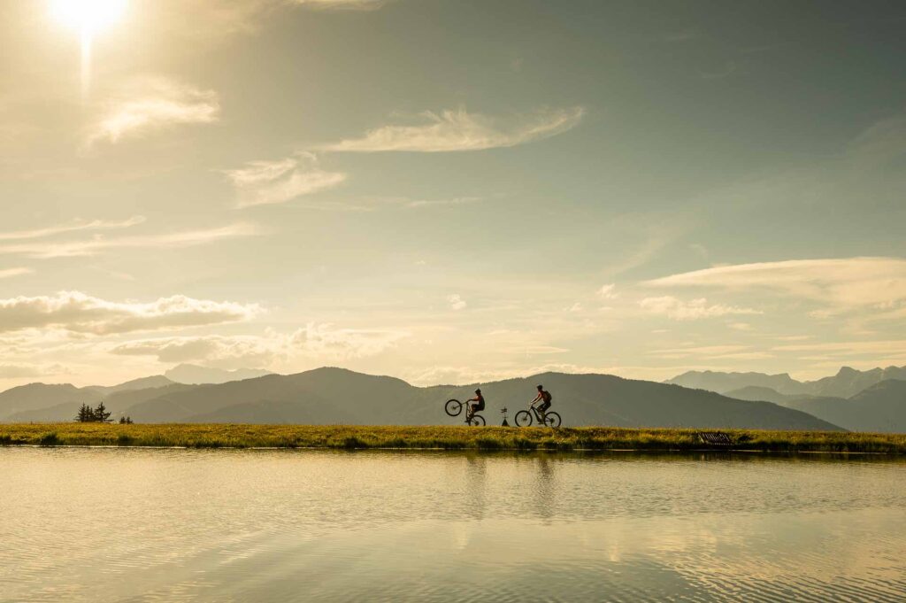 Zwei Radfahrer an einem Bergsee auf einen Gipfel in Altenmarkt-Zauchensee