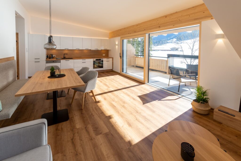 Wohnbereich mit integrierter Küchenzeile und Balkon des Appartements Bergbalance mit Blick auf Altenmarkt im Pongau