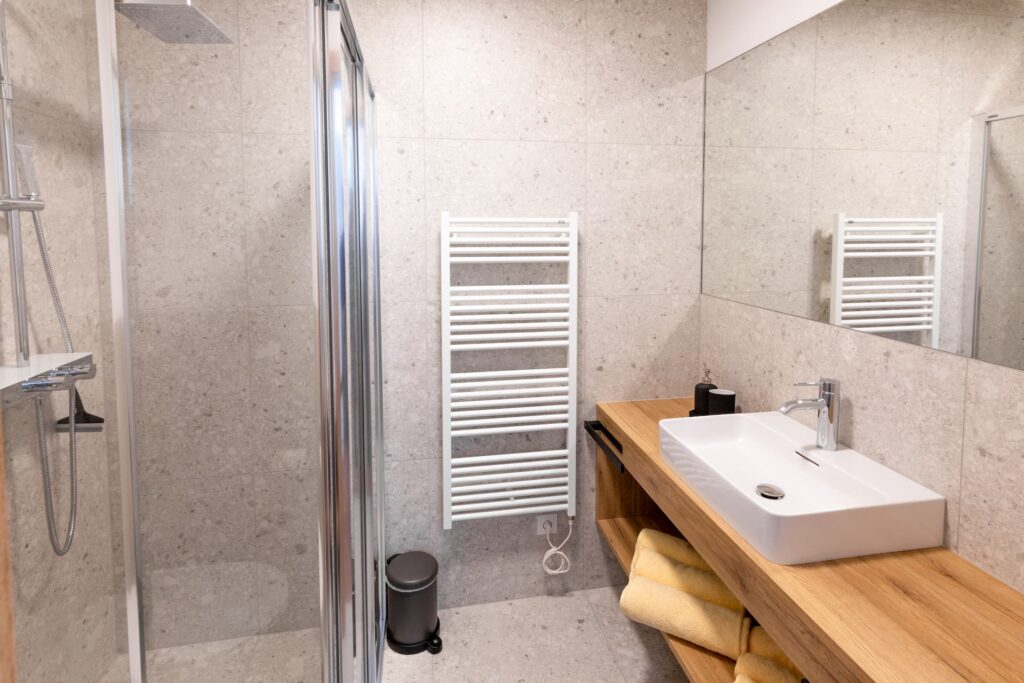 Badezimmer vom Appartement Berglust mit Dusche, Waschbecken und Handtuchtrockner