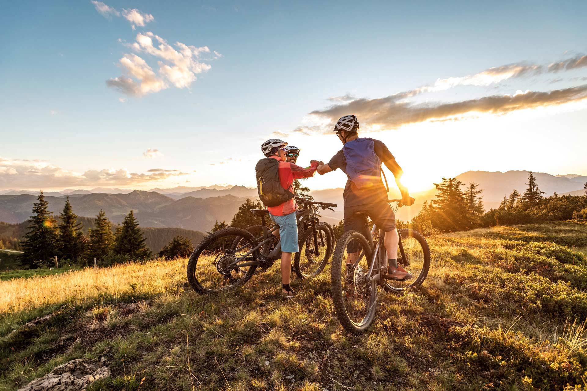 Eine Gruppe Mountainbiker feiert die erfolgreiche Fahrt auf einen der Gipfel in Altenmarkt-Zauchensee