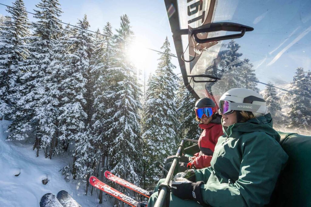 Ein junges Paar beim Fahren mit dem Sessellift auf einen der vielen Gipfel in Altenmarkt-Zauchensee