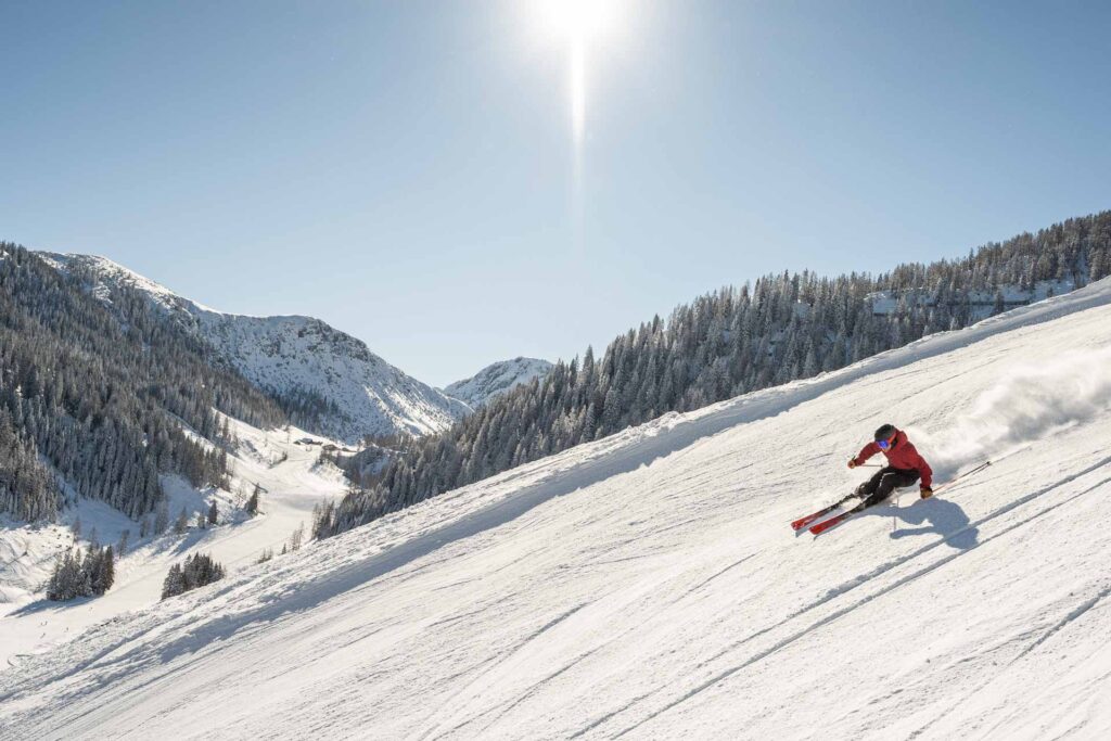 Ein Skifahrer beim Skifahren auf einer Piste in Altenmarkt-Zauchensee